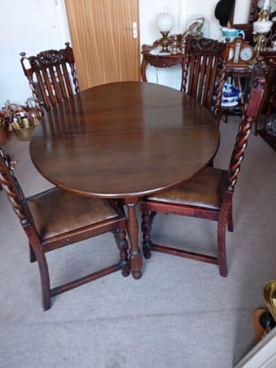A WELSH DARK OAK DINING TABLE (FOLDING) OVAL SHAPE with 4 CHAIRS