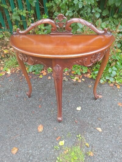 A DEMI-LUNE SIDE TABLE.
