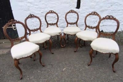 Set of Victorian carved walnut balloon back dining chairs.