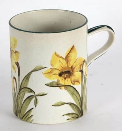 A Wemyss mug painted daffodils within green borders