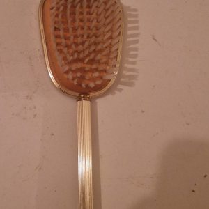 Vintage brass or gold-tone hairbrush with wooden bristles