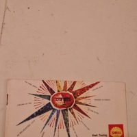 Vintage enamel advertising sign for Shell Oils featuring a sunburst design