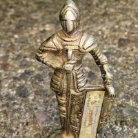 Brass knight figurine in medieval armor with sword and shield
