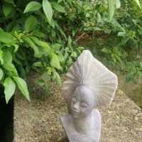 Hand-carved stone bust sculpture of an African woman with elaborate headdress, Shona style