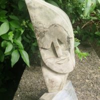 Limestone sculpture depicting a stylized abstract face in Cubist manner