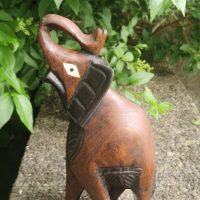 Hand-carved wooden elephant sculpture with trunk raised