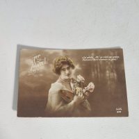French vintage postcard titled ‘1er Avril’ (April Fools’ Day) featuring a glamour portrait of a woman with flowers