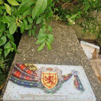 Vintage lithographed tin biscuit container by Huntley &amp; Palmers featuring Scottish tartan and heraldic design