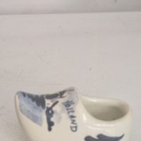 small, hand-painted ceramic Dutch clog souvenir made in the classic Delft blue and white style from Holland
