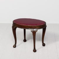 Mahogany oval Chippendale style footstool upholstered in a quality burgundy hide with brass studding