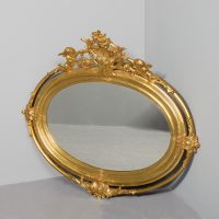 Victorian gilt oval mirror with neoclassical putti and foliate decorated pediment