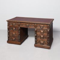 Large Victorian, one-piece carved-oak Flemish kneehole writing desk with Burgundy red leather writing surface.